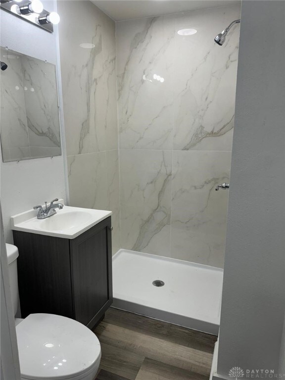 2312 Parkland Ave, Dayton, OH 45405 - full bathroom featuring a stall shower, wood finished floors, toilet, and vanity