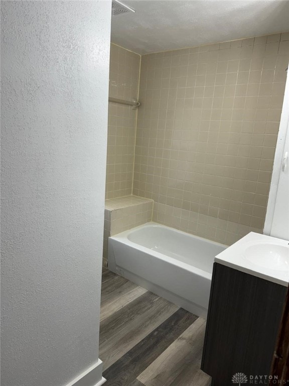 2312 Parkland Ave, Dayton, OH 45405 - bathroom featuring a textured wall,  shower combination, wood finished floors, and vanity