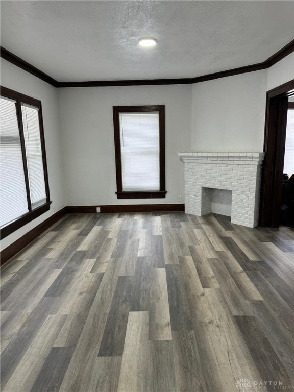 2312 Parkland Ave, Dayton, OH 45405 - unfurnished living room with crown molding, baseboards, a textured ceiling, a fireplace, and wood finished floors