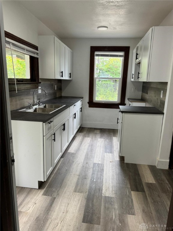 2312 Parkland Ave, Dayton, OH 45405 - kitchen with a sink, dark countertops, plenty of natural light, and wood finished floors