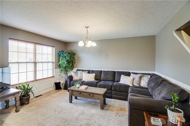 living area with wood finished floors, a chandelier, wainscoting, visible vents, and a textured ceiling