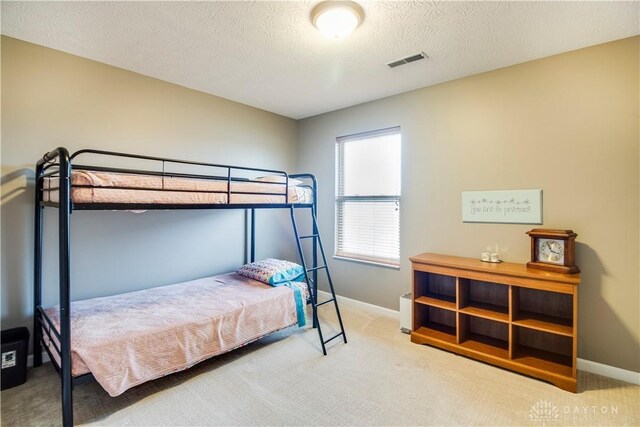 carpeted bedroom featuring visible vents and baseboards