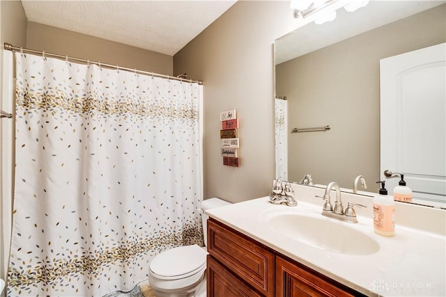 full bathroom with a textured ceiling, vanity, toilet, and curtained shower