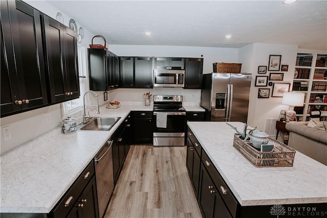4249 Willow Hills Dr, Dayton, OH 45404 - kitchen with stainless steel appliances, a sink, dark cabinets, a center island, and recessed lighting