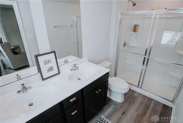 4249 Willow Hills Dr, Dayton, OH 45404 - full bath featuring a stall shower, toilet, wood finished floors, and double vanity