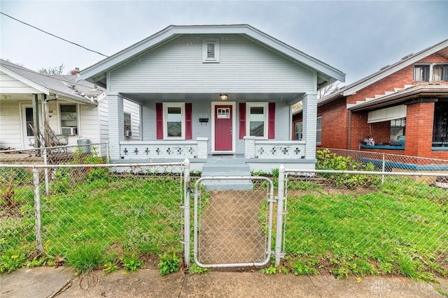 view of front of home featuring a front yard, covered porch, a gate, and a fenced front yard