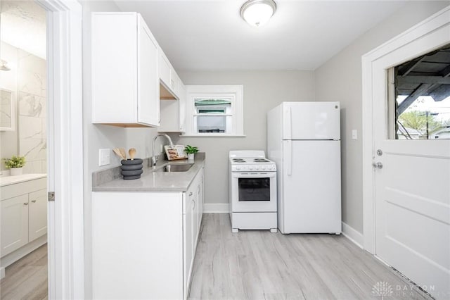kitchen with white cabinets, white appliances, and a sink