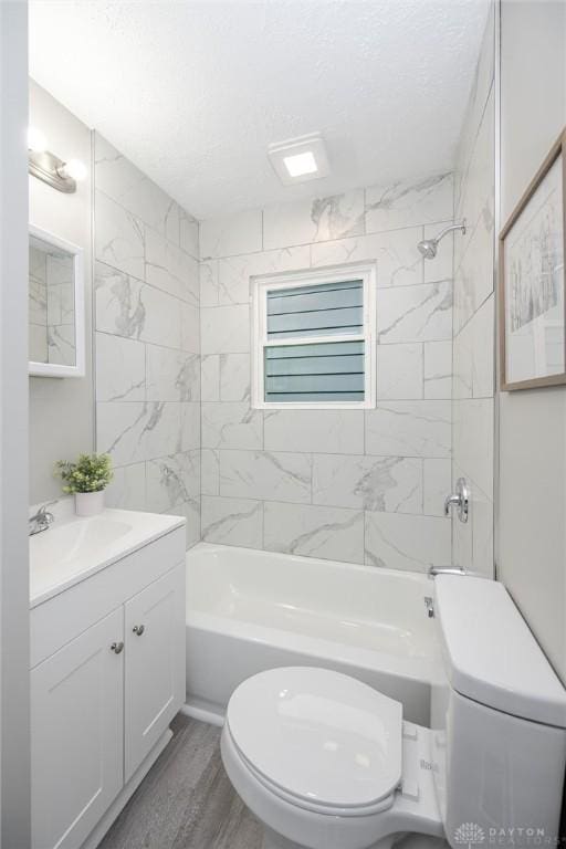 bathroom with toilet, a textured ceiling, bathing tub / shower combination, and vanity