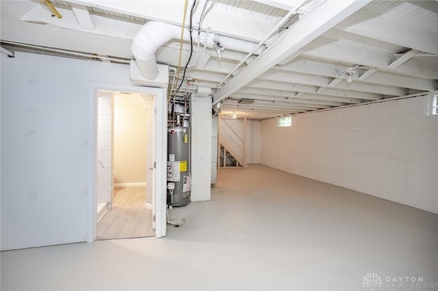 basement featuring stairs and water heater