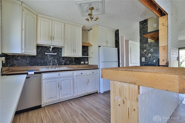 kitchen featuring stainless steel dishwasher, a sink, light wood finished floors, and freestanding refrigerator