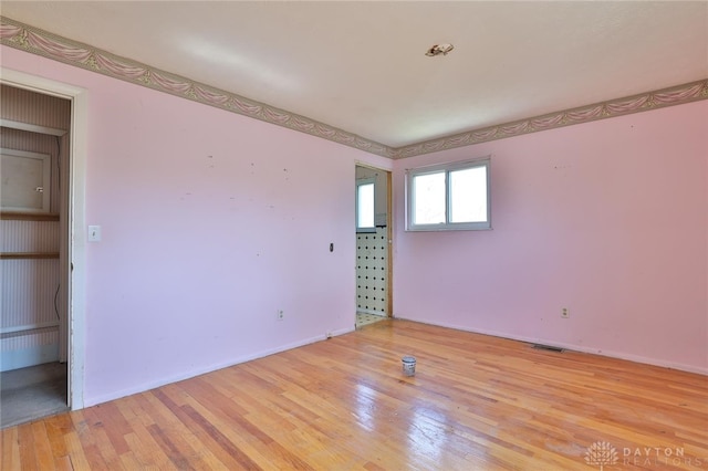spare room featuring light wood-style floors and visible vents