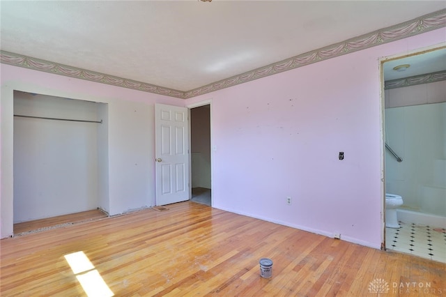 unfurnished bedroom featuring wood finished floors and a closet