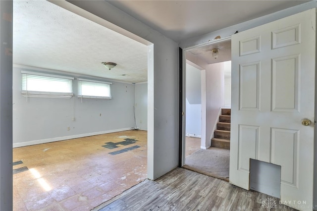 unfurnished room with baseboards and stairs