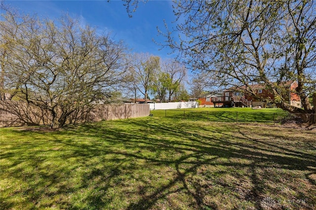 view of yard featuring a wooden deck and fence