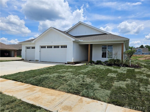 2223 Tandem Dr, Xenia, OH 45385 - view of front of house with concrete driveway, a garage, a front yard, board and batten siding, and roof with shingles