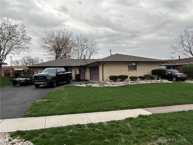 view of front of house with a garage, aphalt driveway, brick siding, a front lawn, and roof with shingles