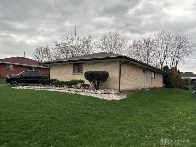 view of property exterior with a lawn and brick siding