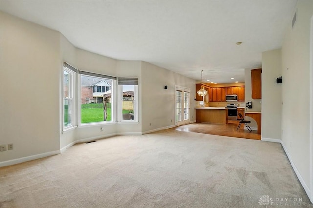 433 Vincent Ct, Middletown, OH 45042 - unfurnished living room featuring light carpet, plenty of natural light, baseboards, a chandelier, and recessed lighting