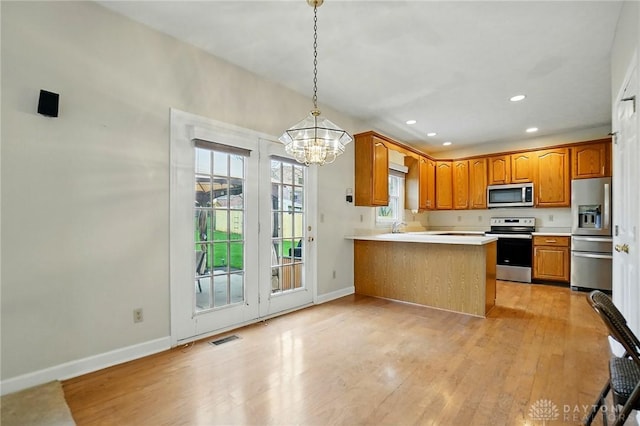 433 Vincent Ct, Middletown, OH 45042 - kitchen featuring stainless steel appliances, a chandelier, brown cabinetry, light wood finished floors, and baseboards