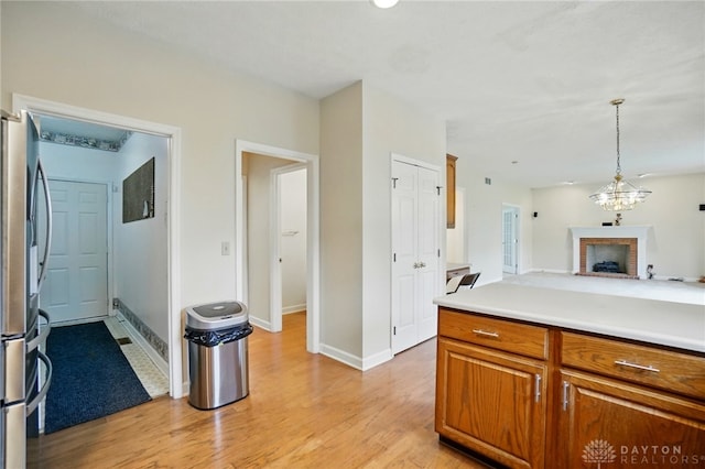 433 Vincent Ct, Middletown, OH 45042 - kitchen with freestanding refrigerator, brown cabinetry, light wood finished floors, baseboards, and open floor plan