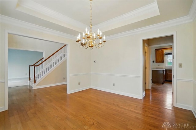 433 Vincent Ct, Middletown, OH 45042 - unfurnished dining area featuring stairway, a tray ceiling, wood finished floors, a chandelier, and crown molding