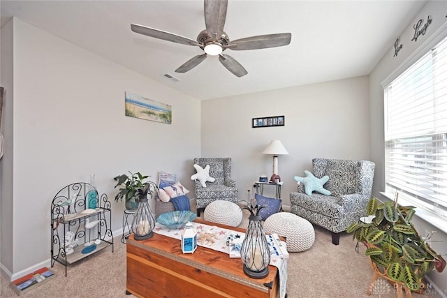 sitting room featuring visible vents, baseboards, carpet flooring, and ceiling fan