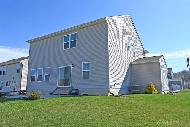 rear view of house with entry steps, a yard, and central AC