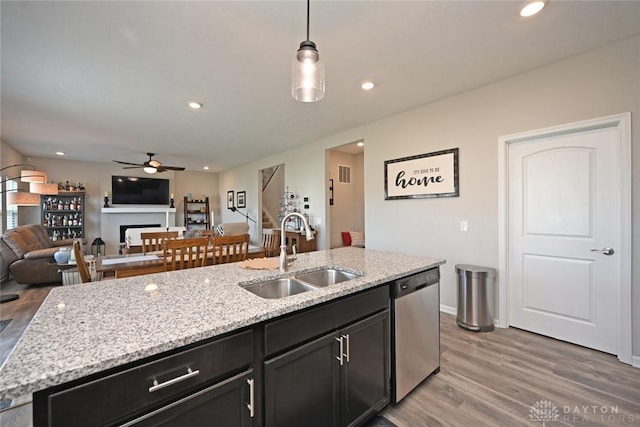 kitchen with a sink, stainless steel dishwasher, a ceiling fan, and wood finished floors