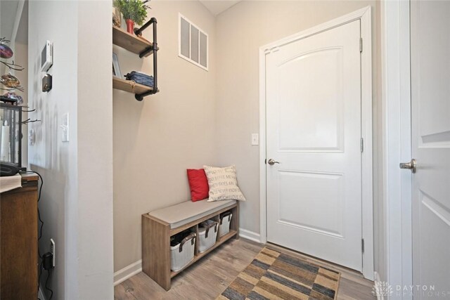 mudroom with visible vents, light wood-type flooring, and baseboards