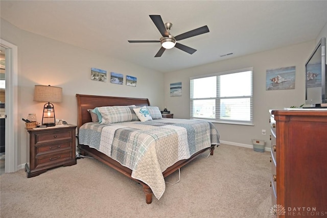 bedroom featuring light carpet, visible vents, baseboards, and a ceiling fan
