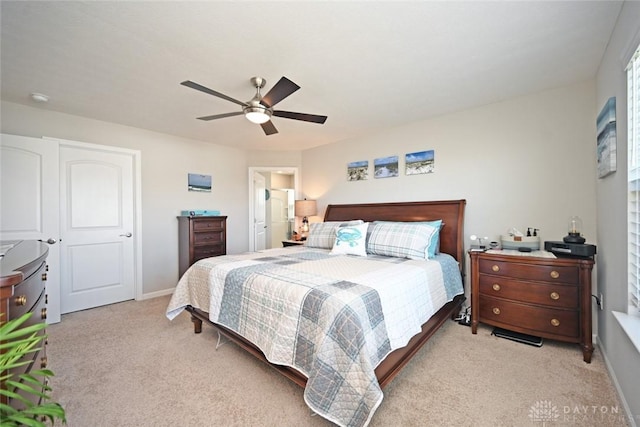 bedroom with light colored carpet, ceiling fan, and baseboards