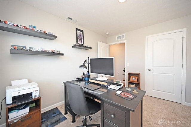 office with visible vents, baseboards, and light carpet