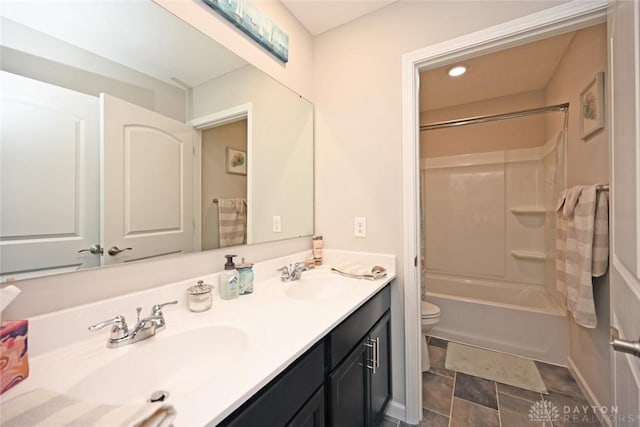 full bathroom with a sink, toilet, double vanity, and shower / bathing tub combination