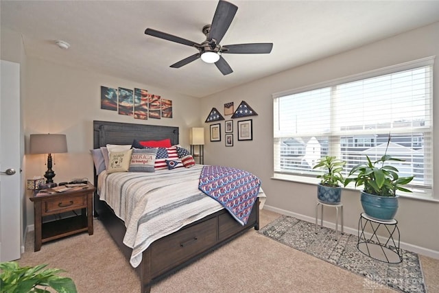 carpeted bedroom featuring baseboards and a ceiling fan
