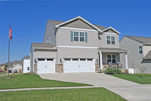 craftsman inspired home featuring a porch, a front yard, stone siding, an attached garage, and concrete driveway