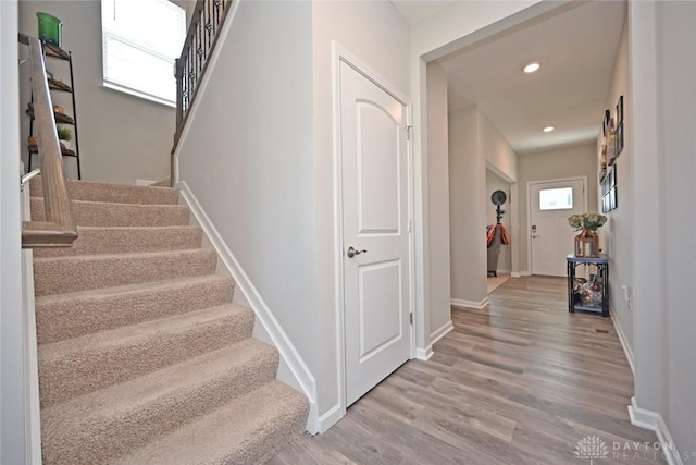 stairway with baseboards, recessed lighting, and wood finished floors