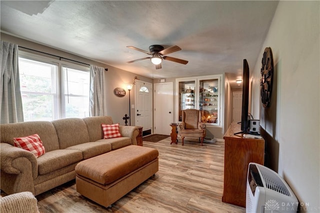 living area featuring light wood finished floors and ceiling fan