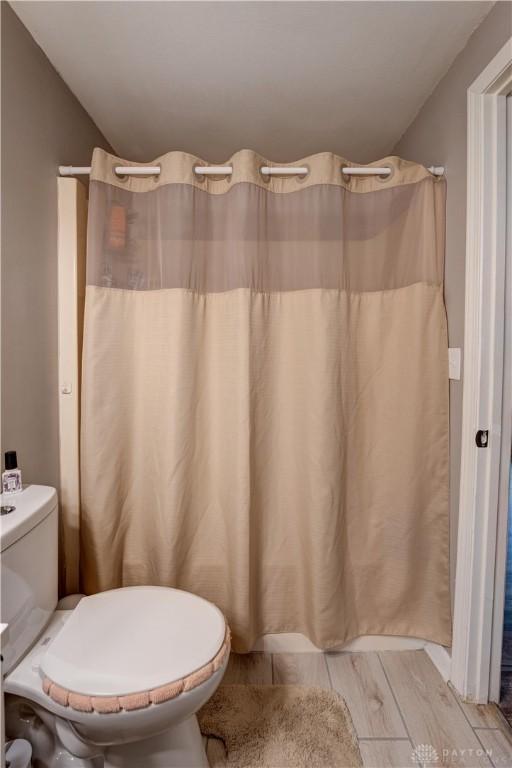full bath featuring toilet and wood finished floors
