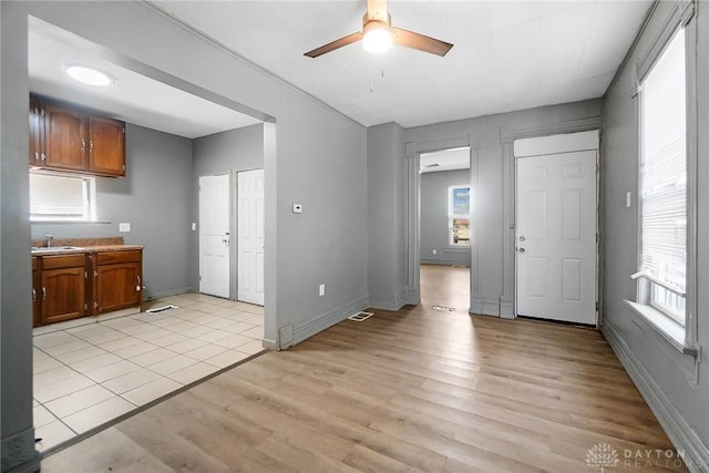 578 Wyoming St, Dayton, OH 45410 - interior space with baseboards, a ceiling fan, light wood-style floors, brown cabinets, and a sink
