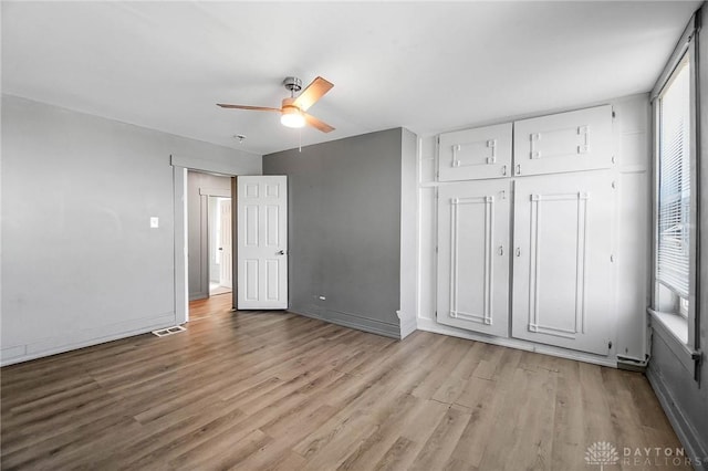 578 Wyoming St, Dayton, OH 45410 - unfurnished bedroom featuring multiple windows, ceiling fan, light wood finished floors, and visible vents