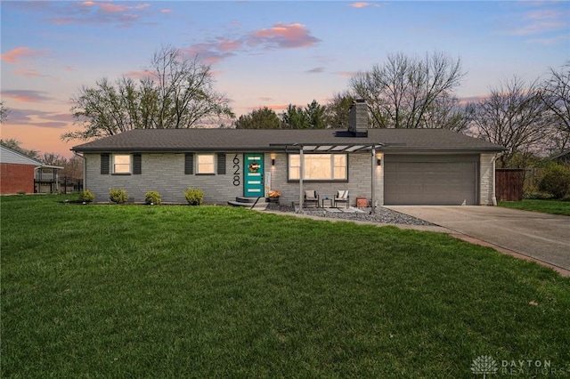single story home with a chimney, a garage, driveway, stone siding, and a front yard