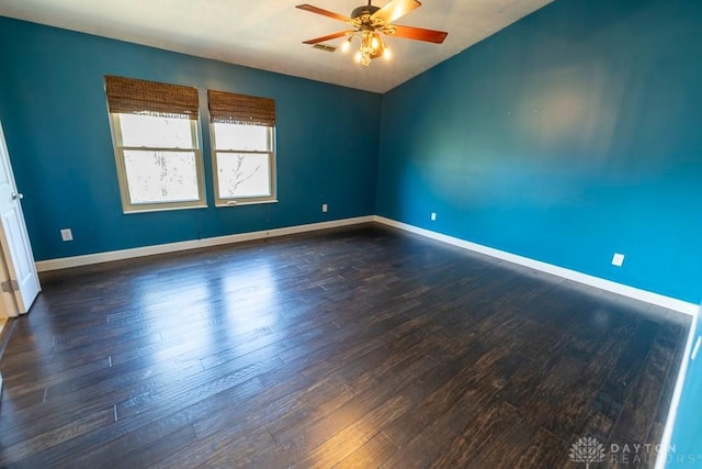 empty room featuring visible vents, baseboards, ceiling fan, vaulted ceiling, and wood finished floors