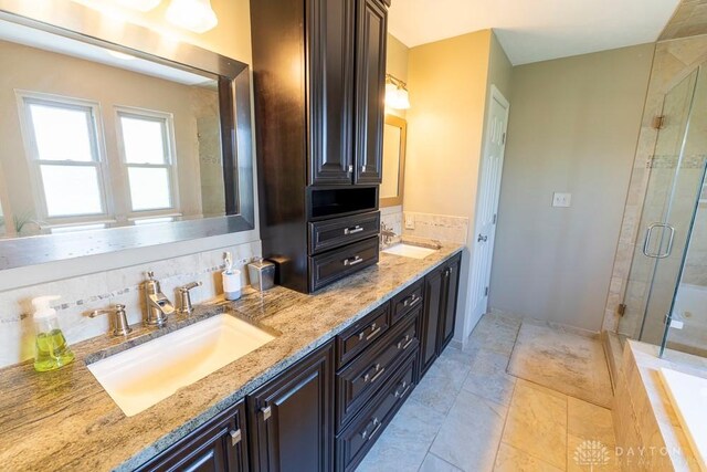 full bath featuring a sink, double vanity, and a stall shower