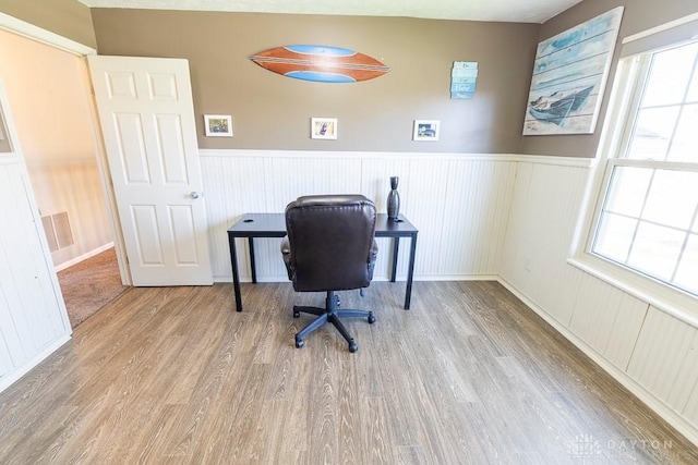 office space with wood finished floors, wainscoting, and a wealth of natural light