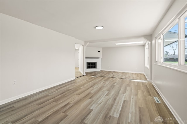 4433 Lambeth Dr, Dayton, OH 45424 - unfurnished living room with baseboards, visible vents, a glass covered fireplace, and light wood finished floors