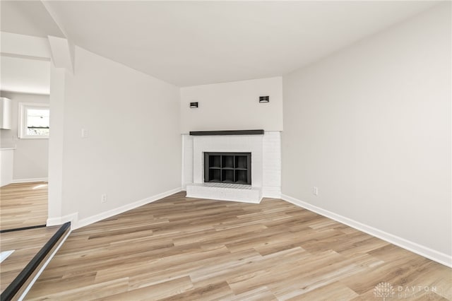 4433 Lambeth Dr, Dayton, OH 45424 - unfurnished living room featuring baseboards, light wood finished floors, and a brick fireplace