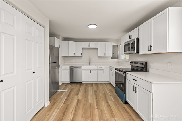 4433 Lambeth Dr, Dayton, OH 45424 - kitchen featuring a sink, appliances with stainless steel finishes, white cabinets, and light wood-style flooring