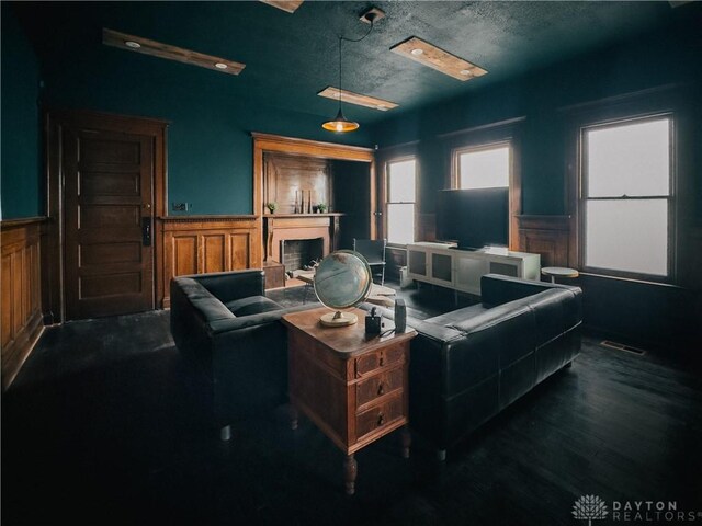 1400 E 3rd St, Dayton, OH 45403 - living room featuring a textured ceiling, dark wood-style flooring, visible vents, and a wainscoted wall