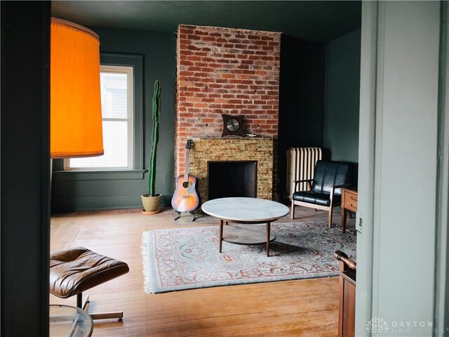 1400 E 3rd St, Dayton, OH 45403 - living area featuring a brick fireplace, radiator, and wood finished floors
