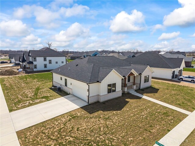 2164 Northbridge Trl, Troy, OH 45373 - view of front of house with a residential view, concrete driveway, a shingled roof, and a garage